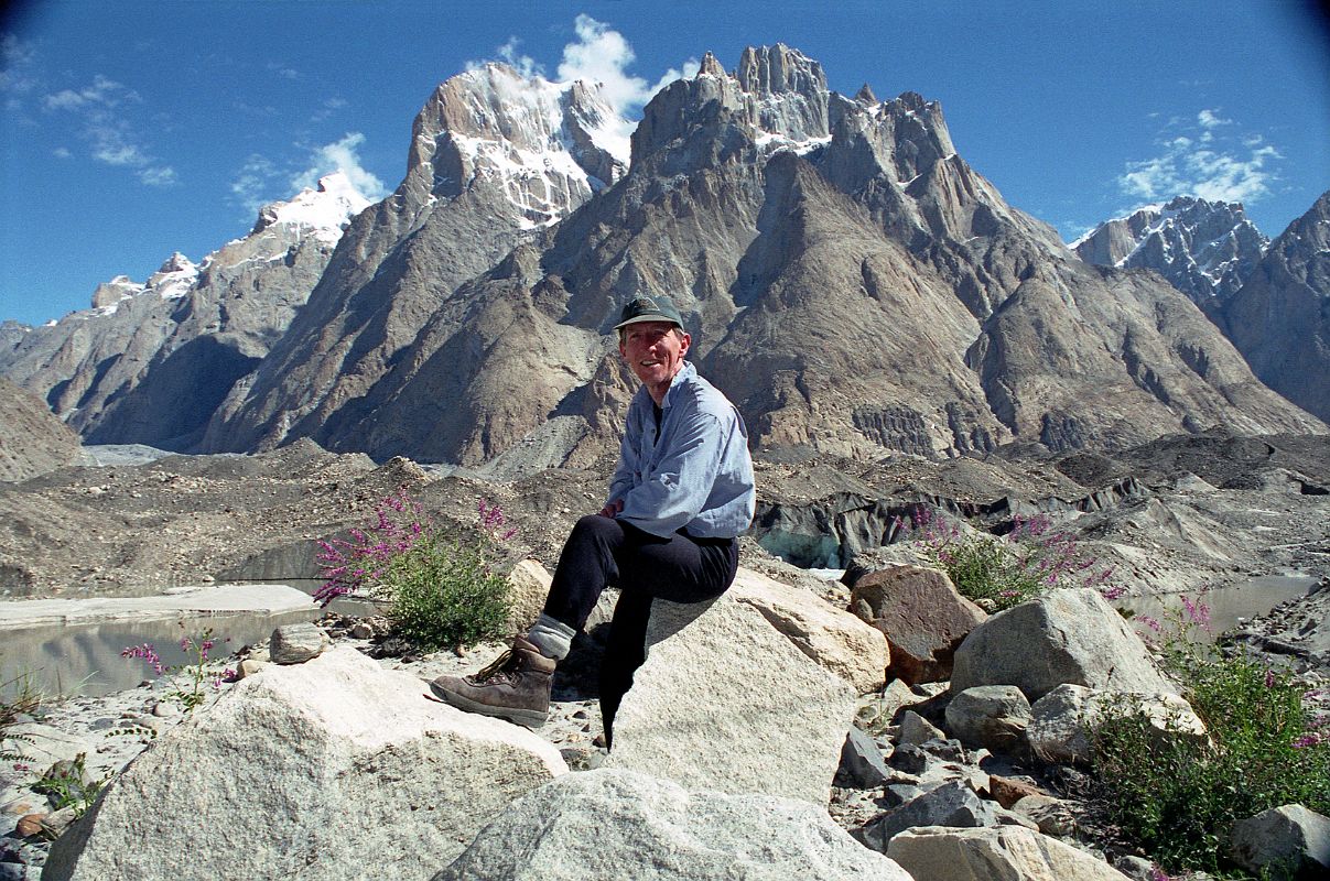 18 Jerome Ryan Poses Above Lake On Baltoro Glacier With Great Trango Tower And Trango Castle Behind Jerome Ryan climbed above a large lake on the Baltoro Glacier amid some grass and small flowers with Trango II, Great Trango Tower and Trango Castle behind  simply spectacular.